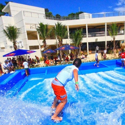 Giochi di sport del parco di divertimenti dell'acqua che praticano il surfing giro del bordo del cavaliere di flusso del simulatore