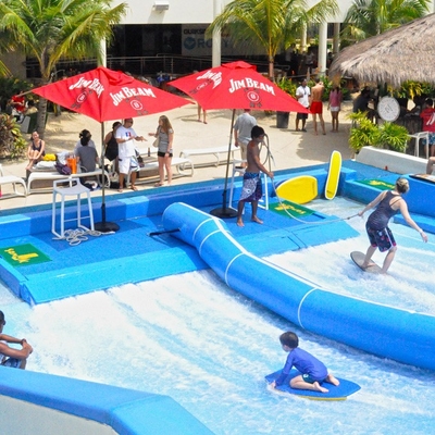 Giro praticante il surfing dell'acqua di Flowrider, giro estremo di divertimento di sport per le attrazioni dell'acqua