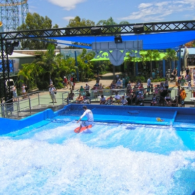 Giro praticante il surfing dell'acqua di Flowrider, giro estremo di divertimento di sport per le attrazioni dell'acqua